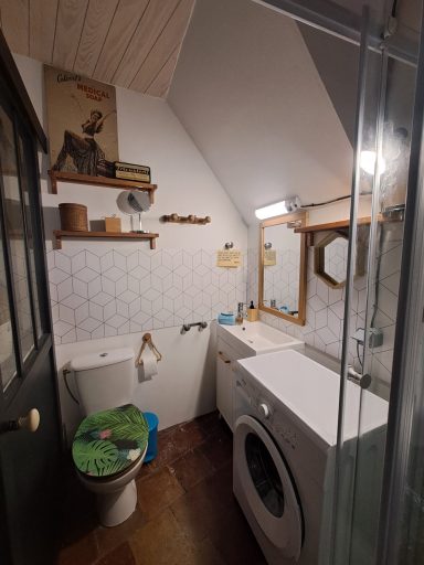 Salle de bain compacte avec douche, lavabo, toilettes et machine à laver.