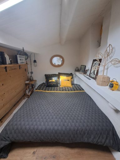 Chambre avec un lit double, des coussins noirs et jaunes, et des murs lumineux.